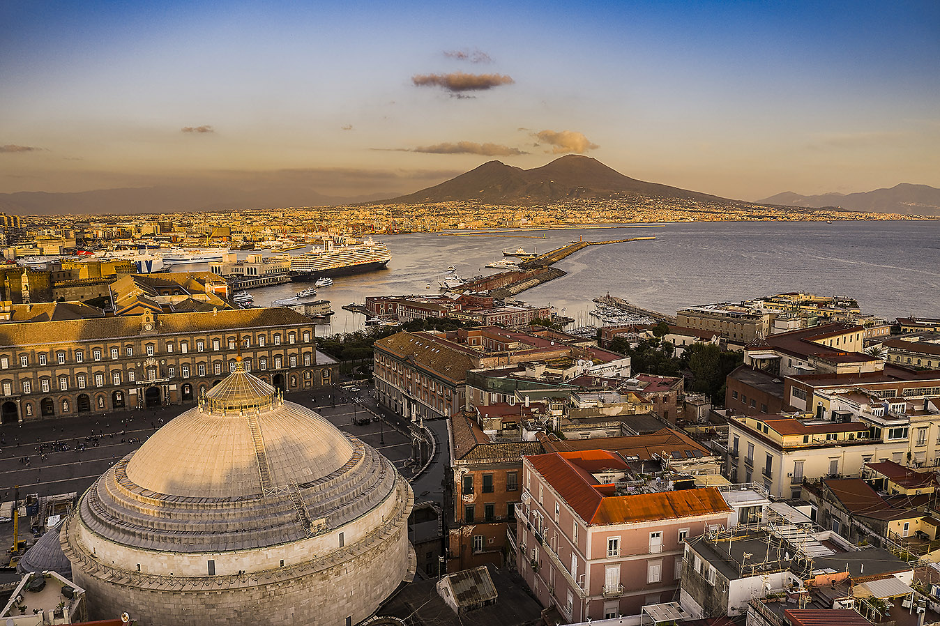 Italy, Naples - view over Piazza Plebiscito with the Royal Palace and, in the foreground, part of the dome of church San Francesco di Paola. In the distance, the Vesuvio
